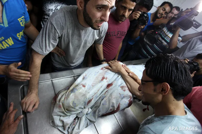 Relatives mourn over the body of 16-year-old Loay Kohail, who was killed during an Israeli air strike on Gaza city, at al-Shifa hospital, 14 July 2018. At least two Palestinians were killed after an Israeli air strike on...