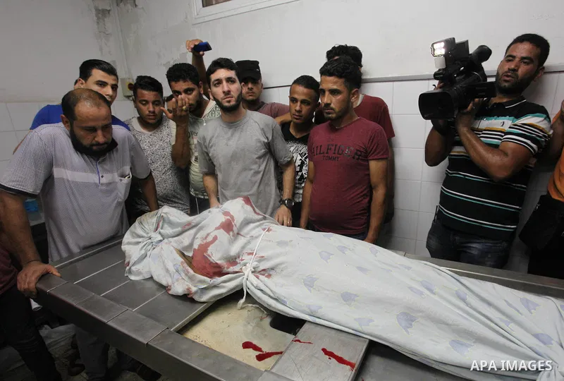 Relatives mourn over the body of 16-year-old Loay Kohail, who was killed during an Israeli air strike on Gaza city, at al-Shifa hospital, 14 July 2018. At least two Palestinians were killed after an Israeli air strike on...