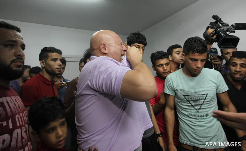Relatives mourn over the body of 16-year-old Loay Kohail, who was killed during an Israeli air strike on Gaza city, at al-Shifa hospital, 14 July 2018. At least two Palestinians were killed after an Israeli air strike on...
