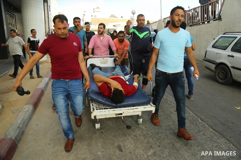 Medics treat a Palestinian man who was injured during an Israeli air strike on Gaza city, at al-Shifa hospital, 14 July 2018. At least two Palestinians were killed after an Israeli air strike on Gaza City. The building i...