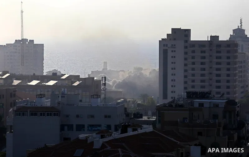 Smoke rises above buildings during an Israeli air strike on Gaza City on July 14, 2018. At least two Palestinians were killed after an Israeli air strike hit an empty building in Gaza City. Photo by Ashraf Amra
