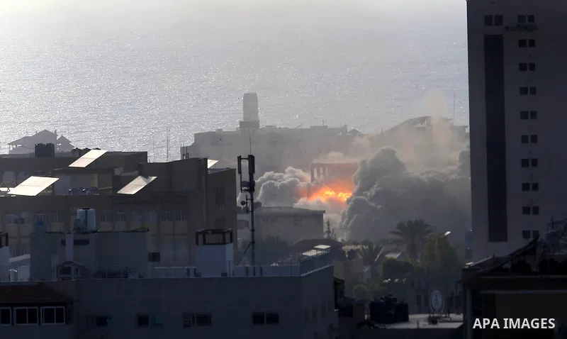 Smoke and fire rises above buildings during an Israeli air strike on Gaza City on July 14, 2018. At least two Palestinians were killed after an Israeli air strike hit an empty building in Gaza City. Photo by Ashraf Amra