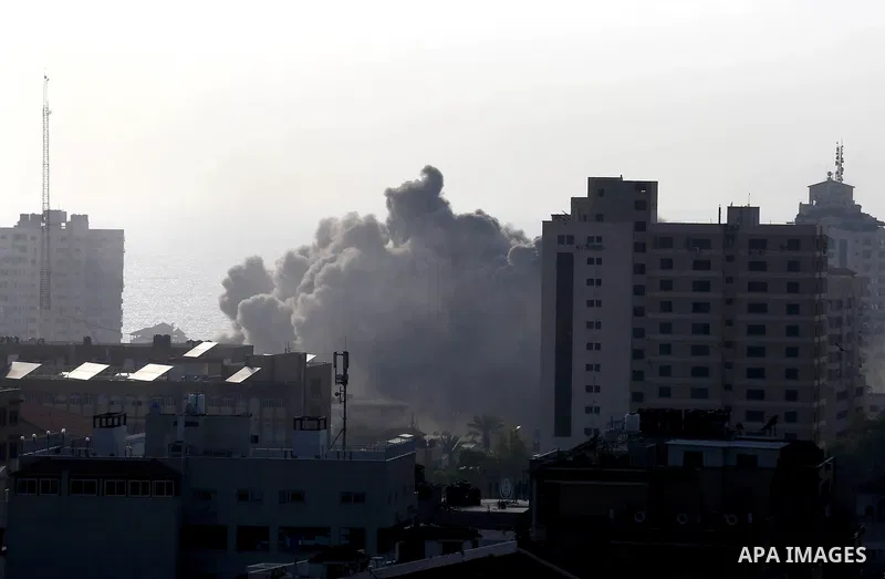 Smoke rises above buildings during an Israeli air strike on Gaza City on July 14, 2018. At least two Palestinians were killed after an Israeli air strike hit an empty building in Gaza City. Photo by Ashraf Amra