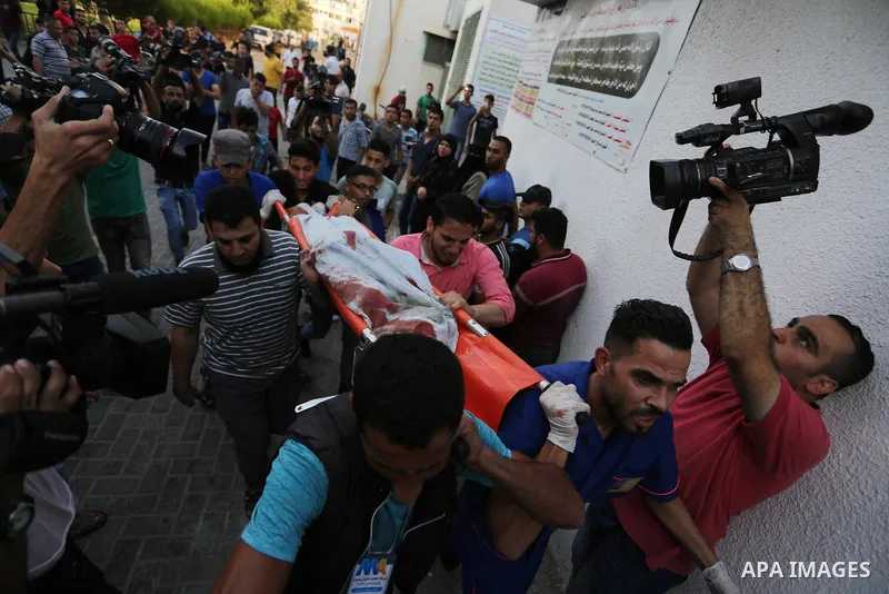 Palestinian medics carry the body of 16-year-old Loay Kuhail, who was killed during an Israeli air strike on Gaza city, at al-Shifa hospital, 14 July 2018. At least two Palestinians were killed after an Israeli air strik...