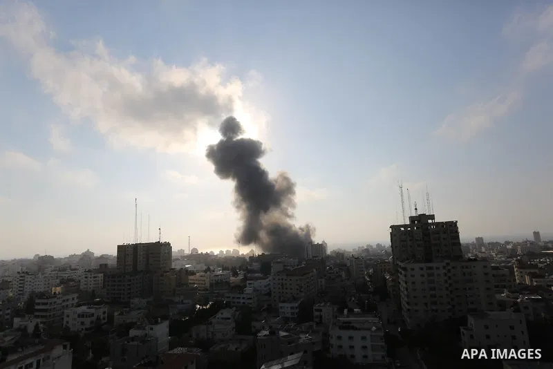 Smoke rises above buildings during an Israeli air strike on Gaza City on July 14, 2018. At least two Palestinians were killed after an Israeli air strike hit an empty building in Gaza City. Photo by Ashraf Amra
