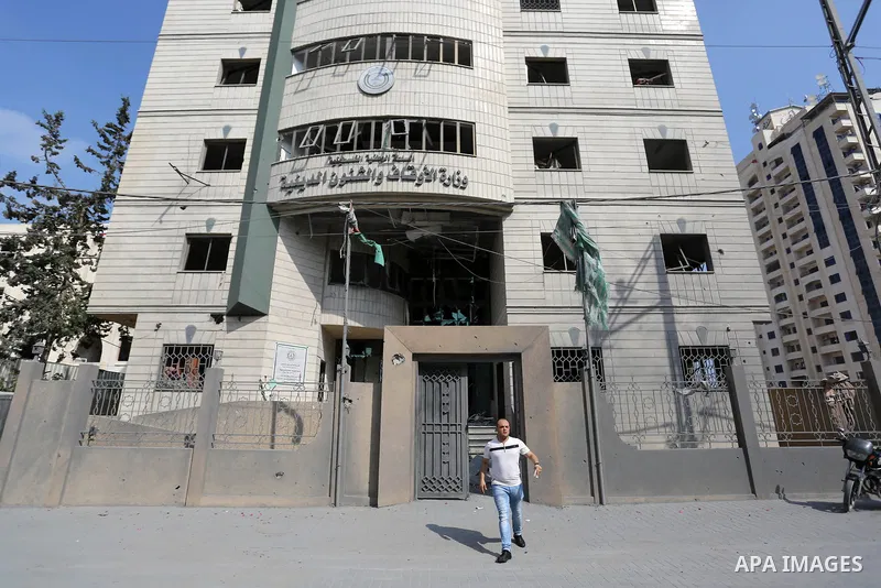 A Palestinian man walks near Ministry of Awqaf building that was damaged in an Israeli airstrike on the Gaza City, on July 15, 2018. At least two Palestinians were killed after an Israeli air strike hit an empty building...