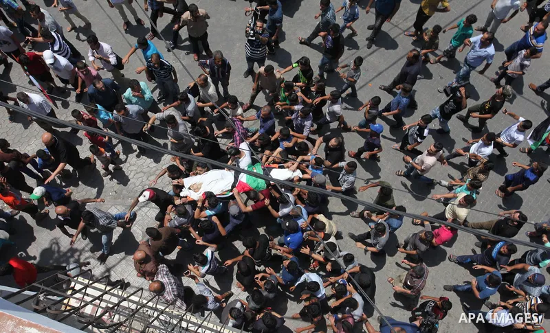 Mourners carry the body of Palestinian Amir Al-Namara, who was killed in an Israeli air strike, during his funeral in Gaza city on July 15, 2018. Photo by Mahmoud Ajour