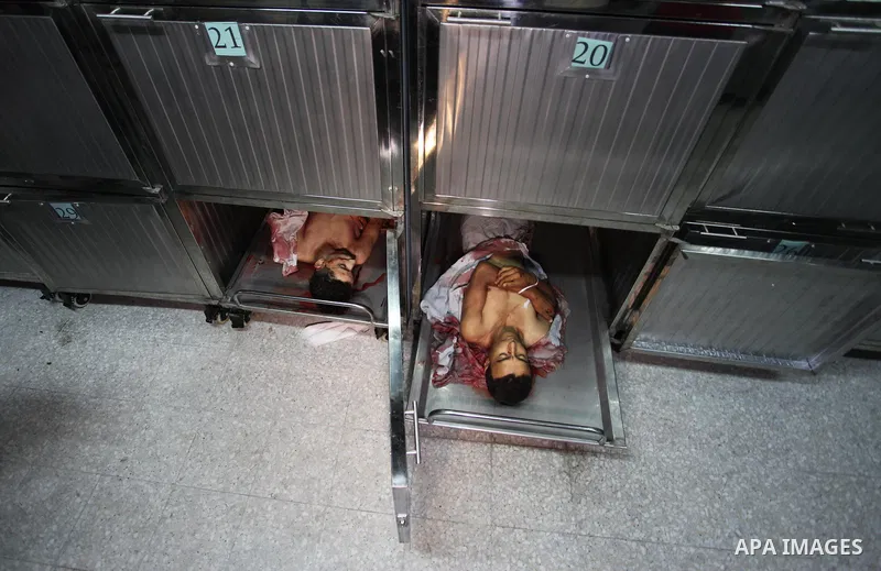 The bodies of two Palestinians, who were killed in an Israeli air strike, are seen at morgue in al-shifa hospital, in Gaza city on July 15, 2018. Photo by Mahmoud Ajour