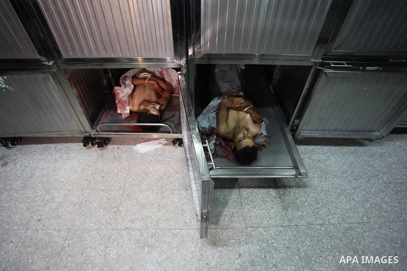 The bodies of two Palestinians, who were killed in an Israeli air strike, are seen at morgue in al-shifa hospital, in Gaza city on July 15, 2018. Photo by Mahmoud Ajour