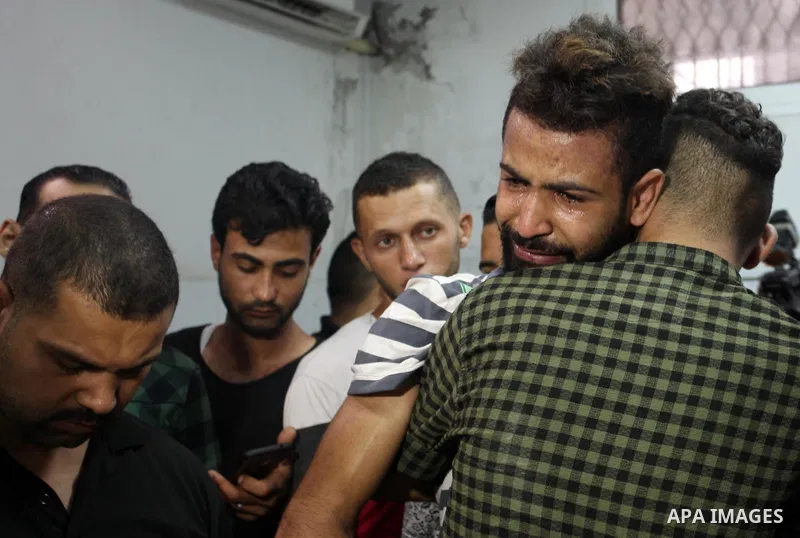 Relatives of two Palestinians who were killed in an unexplained explosion mourn at morgue in al-shifa hospital, in Gaza city on July 15, 2018. Photo by Mahmoud Ajour