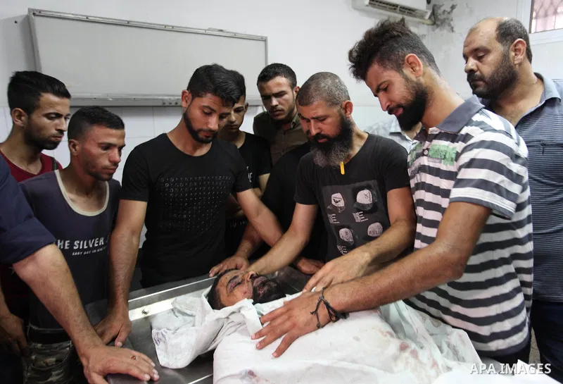 Relatives of Palestinian Ahmed Hassan ,35, who was killed in an unexplained explosion mourn over his body at morgue in al-shifa hospital, in Gaza city on July 15, 2018. Photo by Mahmoud Ajour