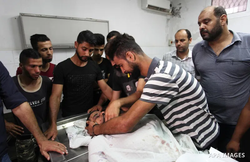 Relatives of Palestinian Ahmed Hassan ,35, who was killed in an unexplained explosion mourn over his body at morgue in al-shifa hospital, in Gaza city on July 15, 2018. Photo by Mahmoud Ajour