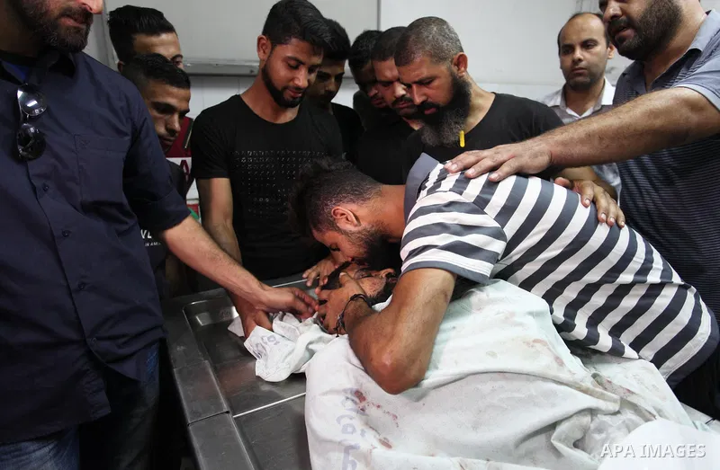 Relatives of Palestinian Ahmed Hassan ,35, who was killed in an unexplained explosion mourn over his body at morgue in al-shifa hospital, in Gaza city on July 15, 2018. Photo by Mahmoud Ajour