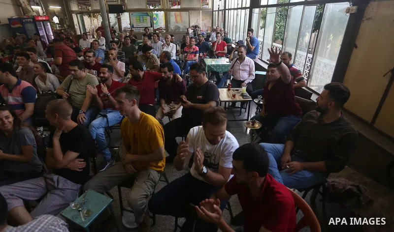 Palestinians watch on a screen the Russia 2018 World Cup final football match between France and Croatia, in the West Bank city of Nablus on July 15, 2018. Photo by Shadi Jarar'ah