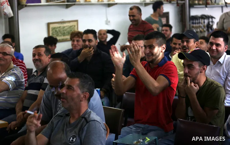 Palestinians watch on a screen the Russia 2018 World Cup final football match between France and Croatia, in the West Bank city of Nablus on July 15, 2018. Photo by Shadi Jarar'ah