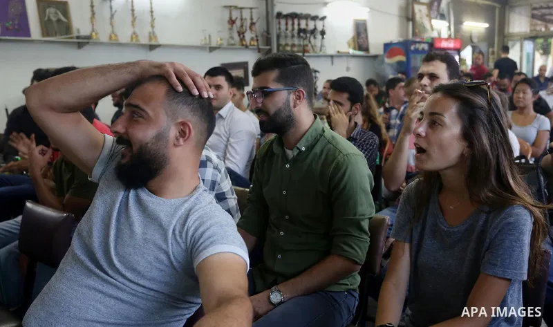 Palestinians watch on a screen the Russia 2018 World Cup final football match between France and Croatia, in the West Bank city of Nablus on July 15, 2018. Photo by Shadi Jarar'ah