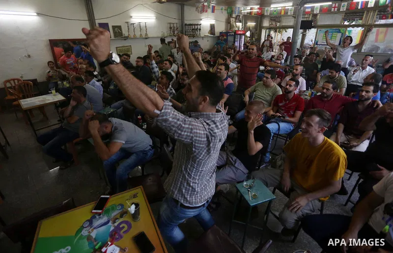 Palestinians watch on a screen the Russia 2018 World Cup final football match between France and Croatia, in the West Bank city of Nablus on July 15, 2018. Photo by Shadi Jarar'ah