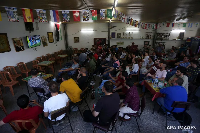 Palestinians watch on a screen the Russia 2018 World Cup final football match between France and Croatia, in the West Bank city of Nablus on July 15, 2018. Photo by Shadi Jarar'ah