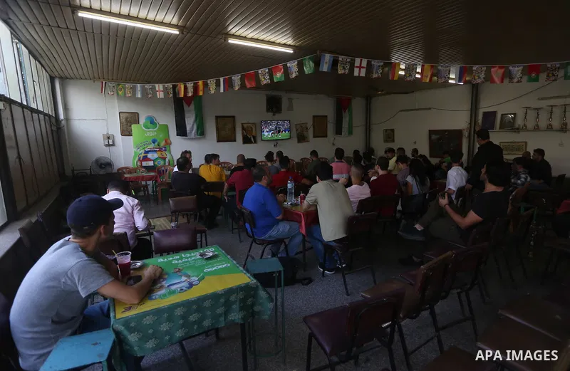 Palestinians watch on a screen the Russia 2018 World Cup final football match between France and Croatia, in the West Bank city of Nablus on July 15, 2018. Photo by Shadi Jarar'ah