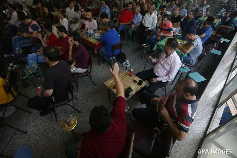 Palestinians watch on a screen the Russia 2018 World Cup final football match between France and Croatia, in the West Bank city of Nablus on July 15, 2018. Photo by Shadi Jarar'ah