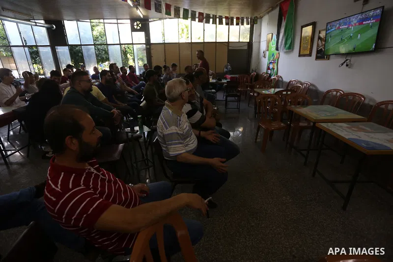Palestinians watch on a screen the Russia 2018 World Cup final football match between France and Croatia, in the West Bank city of Nablus on July 15, 2018. Photo by Shadi Jarar'ah