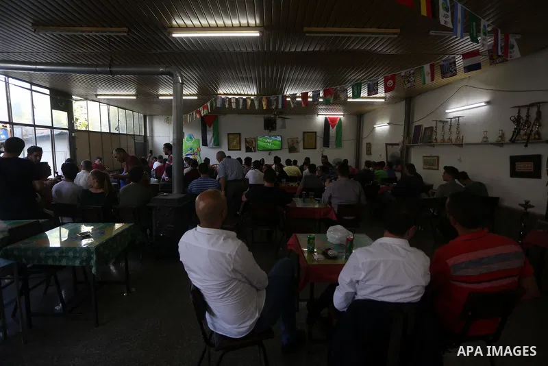 Palestinians watch on a screen the Russia 2018 World Cup final football match between France and Croatia, in the West Bank city of Nablus on July 15, 2018. Photo by Shadi Jarar'ah