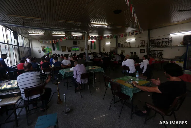 Palestinians watch on a screen the Russia 2018 World Cup final football match between France and Croatia, in the West Bank city of Nablus on July 15, 2018. Photo by Shadi Jarar'ah
