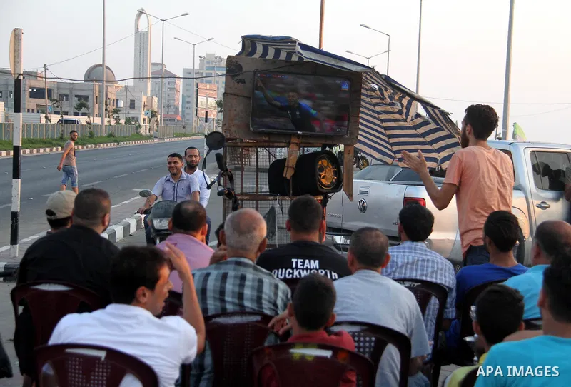 Palestinians watch on a screen the Russia 2018 World Cup final football match between France and Croatia, in Gaza city, on July 15, 2018. France defeated Croatia 4-2 and claimed the title. Photo by Mahmoud Ajour