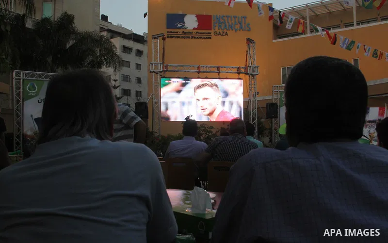 Palestinians watch on a screen the Russia 2018 World Cup final football match between France and Croatia, in Gaza city, on July 15, 2018. France defeated Croatia 4-2 and claimed the title. Photo by Mahmoud Ajour