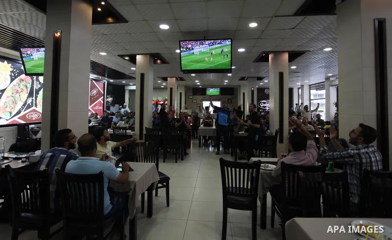 Palestinians watch on a screen the Russia 2018 World Cup final football match between France and Croatia, in Gaza city, on July 15, 2018. France defeated Croatia 4-2 and claimed the title. Photo by Mahmoud Ajour
