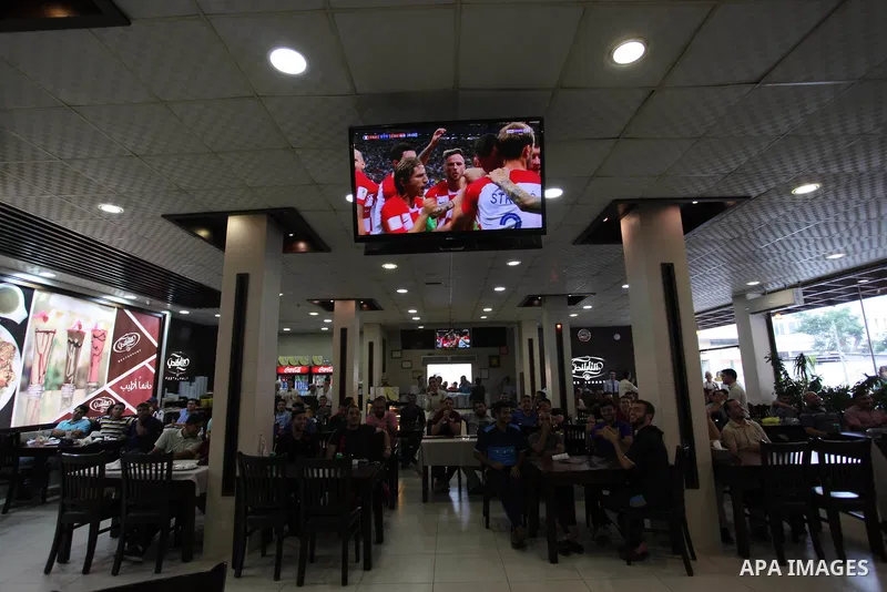 Palestinians watch on a screen the Russia 2018 World Cup final football match between France and Croatia, in Gaza city, on July 15, 2018. France defeated Croatia 4-2 and claimed the title. Photo by Mahmoud Ajour