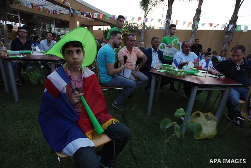 Palestinians watch on a screen the Russia 2018 World Cup final football match between France and Croatia, in Gaza city, on July 15, 2018. France defeated Croatia 4-2 and claimed the title. Photo by Mahmoud Ajour