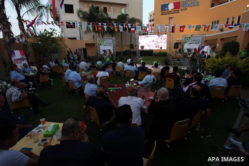 Palestinians watch on a screen the Russia 2018 World Cup final football match between France and Croatia, in Gaza city, on July 15, 2018. France defeated Croatia 4-2 and claimed the title. Photo by Mahmoud Ajour
