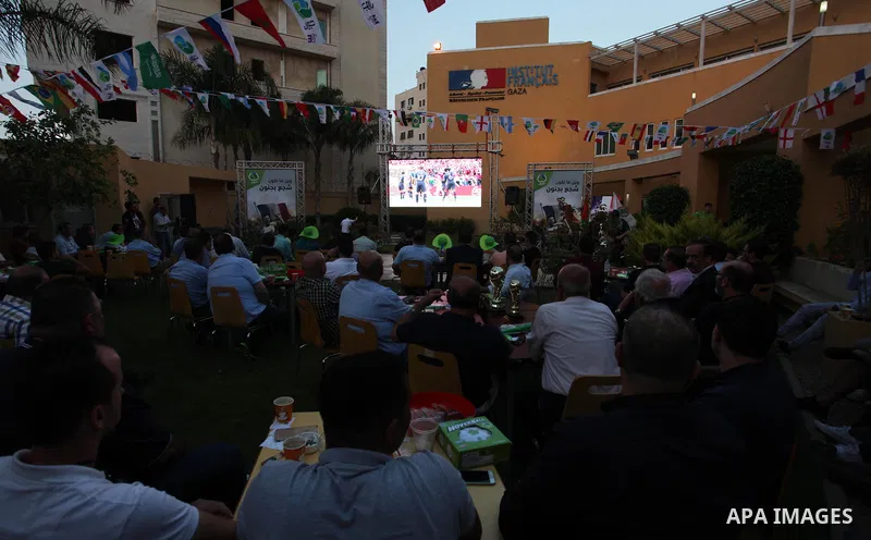 Palestinians watch on a screen the Russia 2018 World Cup final football match between France and Croatia, in Gaza city, on July 15, 2018. France defeated Croatia 4-2 and claimed the title. Photo by Mahmoud Ajour