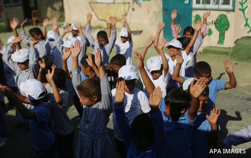 Palestinian schoolchildren stand in a line on the first day of a new school year, at Khan al-Ahmar's school at the Palestinian Bedouin village of Khan al-Ahmar, east of Jerusalem in the occupied West Bank on July 16, 201...