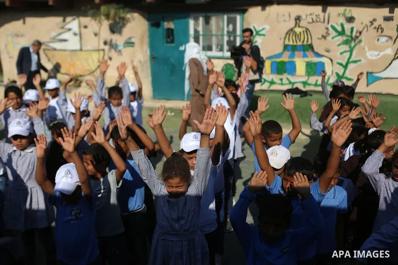 Palestinian schoolchildren stand in a line on the first day of a new school year, at Khan al-Ahmar's school at the Palestinian Bedouin village of Khan al-Ahmar, east of Jerusalem in the occupied West Bank on July 16, 201...
