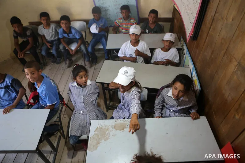 Palestinian schoolchildren sit inside their classrooms on the first day of a new school year, at Khan al-Ahmar's school at the Palestinian Bedouin village of Khan al-Ahmar, east of Jerusalem in the occupied West Bank on...
