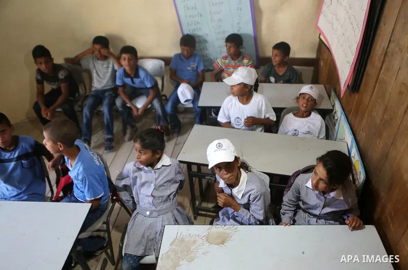 Palestinian schoolchildren sit inside their classrooms on the first day of a new school year, at Khan al-Ahmar's school at the Palestinian Bedouin village of Khan al-Ahmar, east of Jerusalem in the occupied West Bank on...