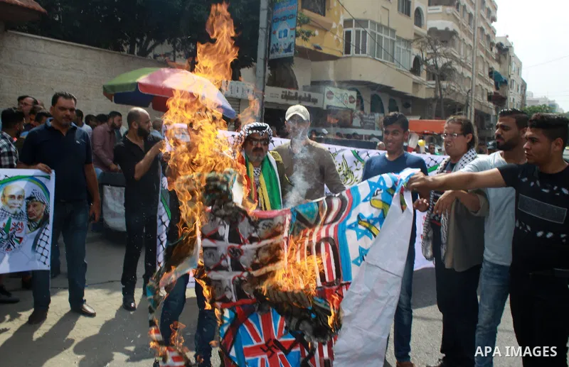 Palestinians burn an Israeli, British and U.S. flags during a protest to show solidarity with Palestinian prisoners held in Israeli jails, in front of Red cross office in Gaza city on July 16, 2018. Photo by Bashar Zakri