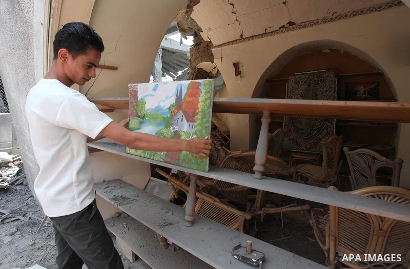 Palestinian artists take part in an exhibition against the bombing of the Arts and Crafts Village that was damaged in an Israeli airstrike on the Gaza City, on July 16, 2018. Photo by Mahmoud Ajour