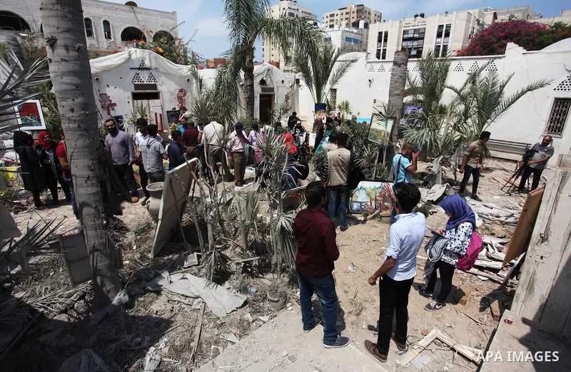 Palestinian artists take part in an exhibition against the bombing of the Arts and Crafts Village that was damaged in an Israeli airstrike on the Gaza City, on July 16, 2018. Photo by Mahmoud Ajour