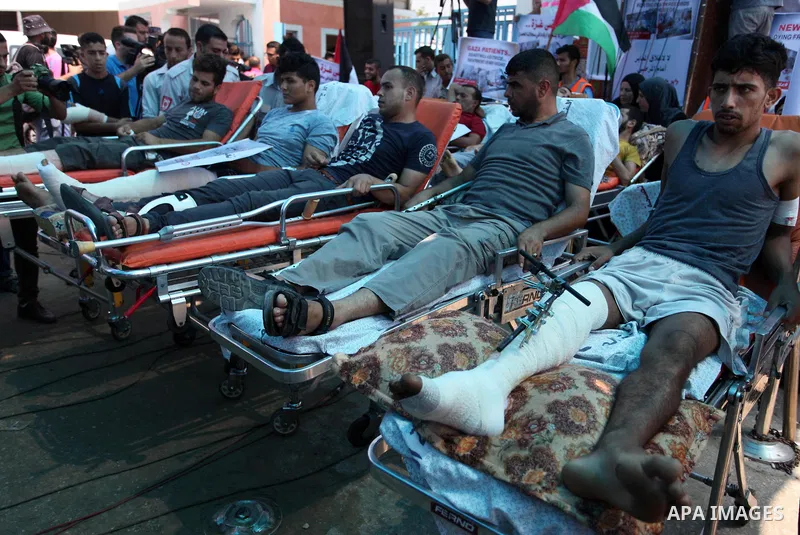 Palestinians who were wounded by Israeli troops during clashes at Israeli-Gaza border, take part in a protest to demand their rights to travel for treatment and against the siege on the Gaza Strip, at Erez crossing, in t...