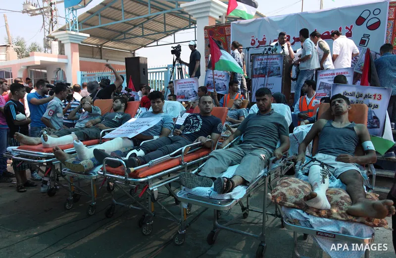 Palestinians who were wounded by Israeli troops during clashes at Israeli-Gaza border, take part in a protest to demand their rights to travel for treatment and against the siege on the Gaza Strip, at Erez crossing, in t...