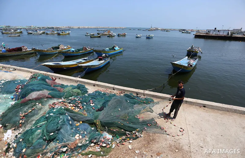 Palestinian fishermen ride their boat at the seaport of Gaza City on July 17, 2018, while the fishing zone enforced by Israel off the Gaza Strip was also reduced from six nautical miles to three. Israel tightened its blo...
