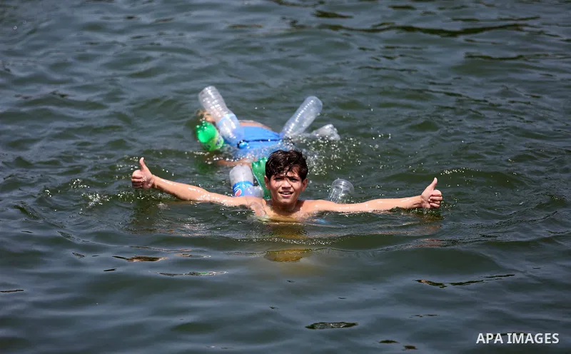 Palestinian children swim at the seaport of Gaza City on July 17, 2018, while the fishing zone enforced by Israel off the Gaza Strip was also reduced from six nautical miles to three. Israel tightened its blockade of the...