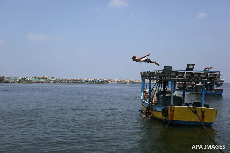A Palestinian man swims at the seaport of Gaza City on July 17, 2018, while the fishing zone enforced by Israel off the Gaza Strip was also reduced from six nautical miles to three. Israel tightened its blockade of the G...