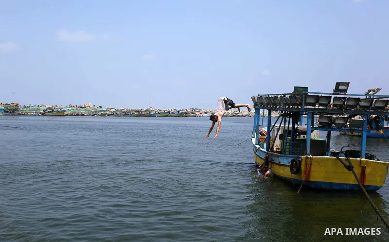 A Palestinian man swims at the seaport of Gaza City on July 17, 2018, while the fishing zone enforced by Israel off the Gaza Strip was also reduced from six nautical miles to three. Israel tightened its blockade of the G...
