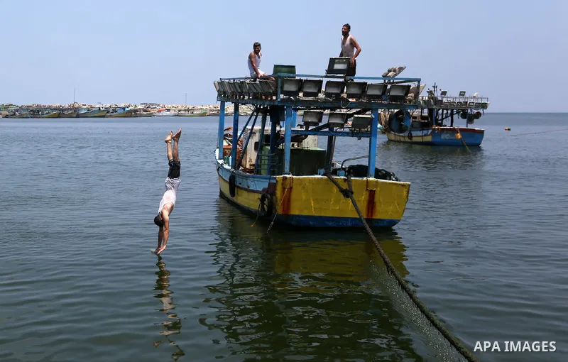 Palestinian fishermen ride their boat at the seaport of Gaza City on July 17, 2018, while the fishing zone enforced by Israel off the Gaza Strip was also reduced from six nautical miles to three. Israel tightened its blo...