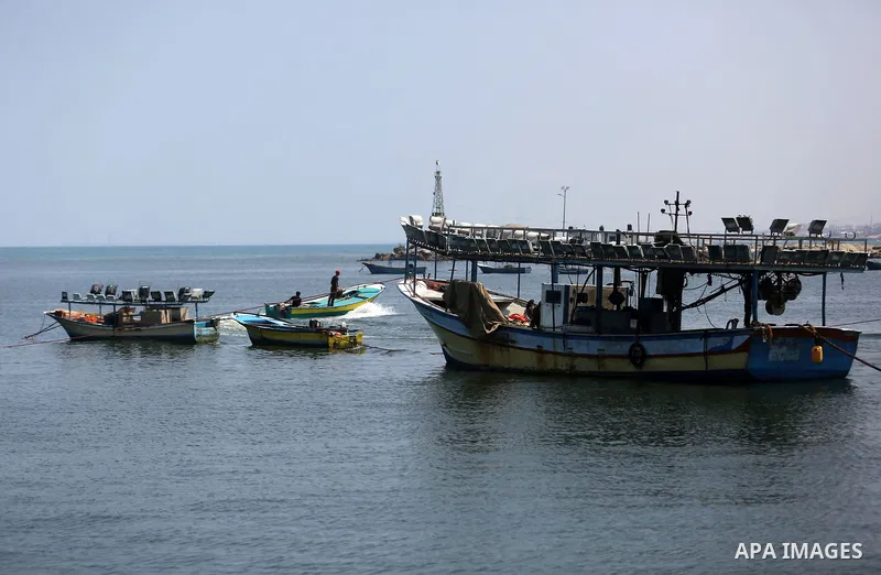 Palestinian fishermen ride their boat at the seaport of Gaza City on July 17, 2018, while the fishing zone enforced by Israel off the Gaza Strip was also reduced from six nautical miles to three. Israel tightened its blo...