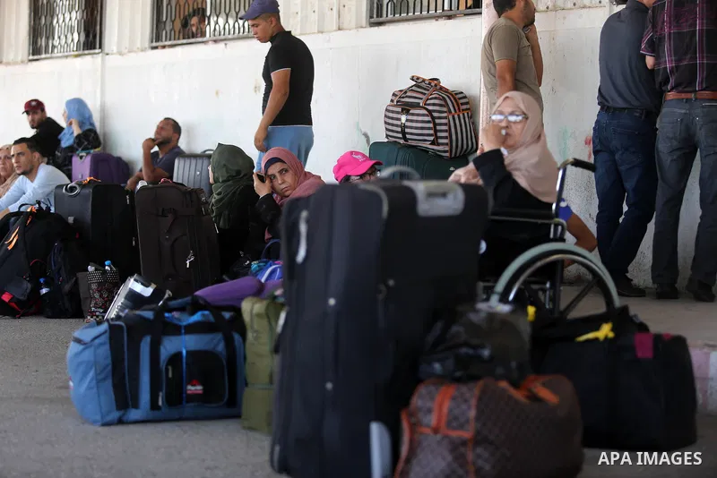 Palestinians wait for travel permits to cross into Egypt through the Rafah border crossing in Khan Yunis in the southern Gaza Strip on July 18, 2018. Photo by Ashraf Amra